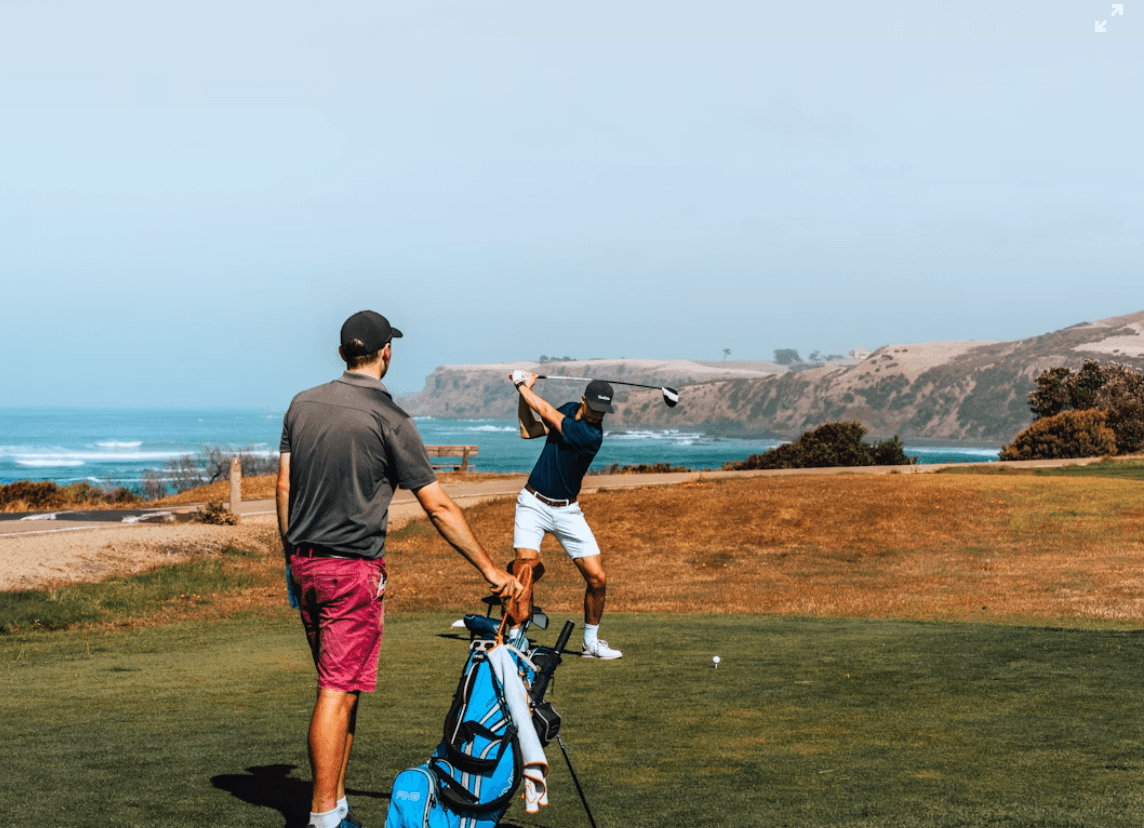 Two golfers on a coastal course